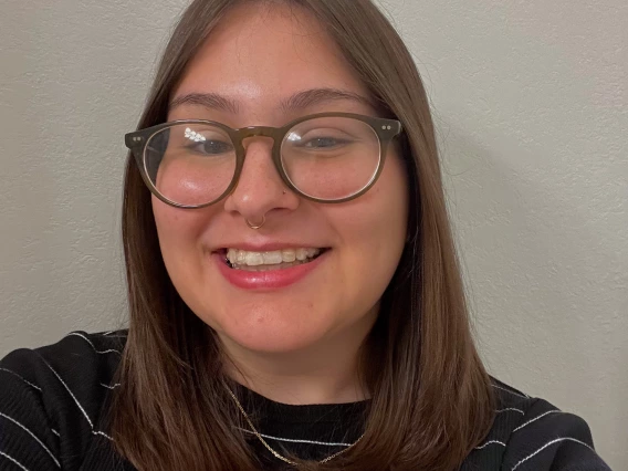 a photo of a person smiling in front of a blank background