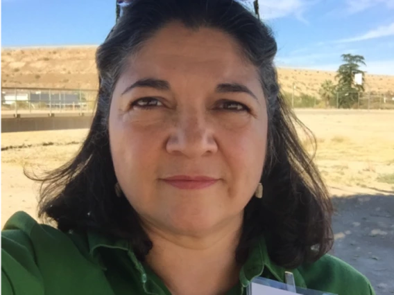 photo of a person in green blouse in front of an open field