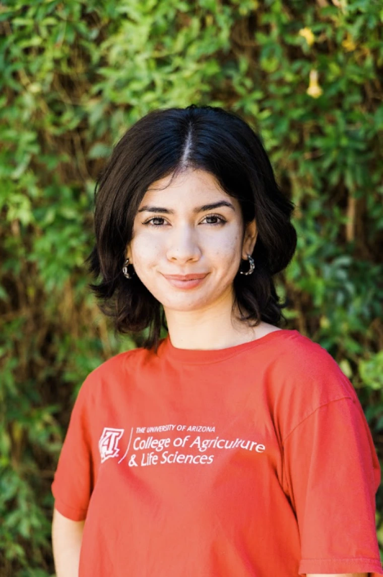 Iliana Samorano, photo of person in red T shirt in front of greenery