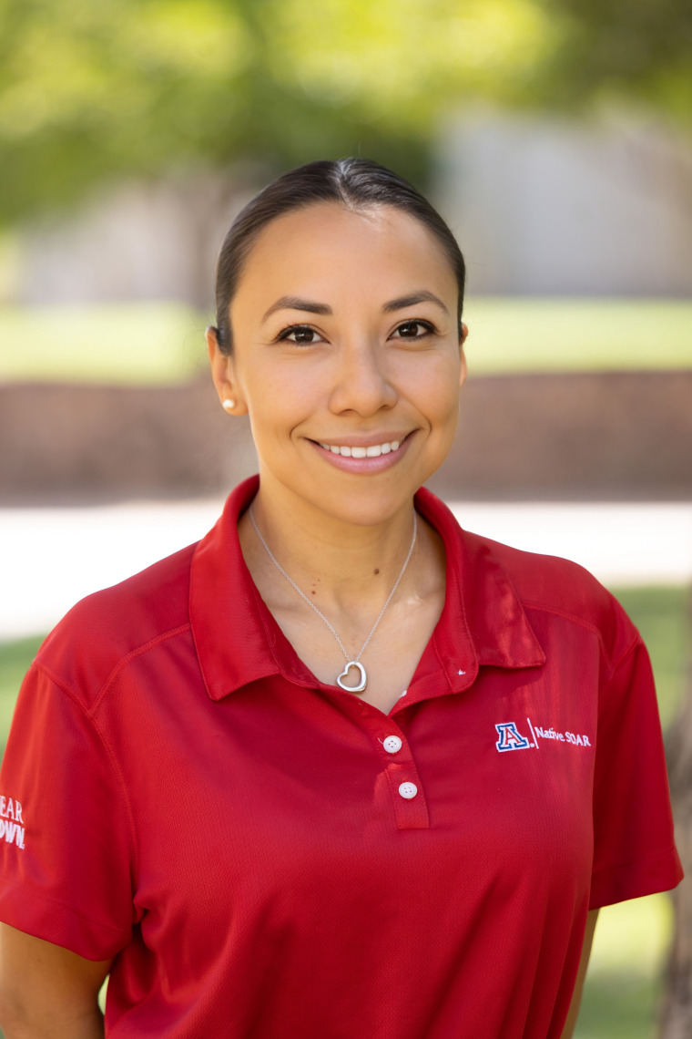 a photo of a person in a red polo shirt in front of a blurred outdoor scene